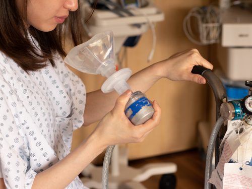 Patient holding a mask next to a gas tank.